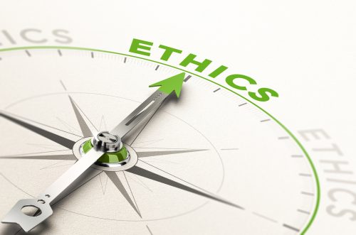A compass with needle pointing the word ethics
